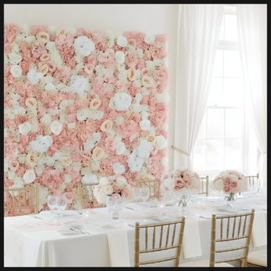 A pink and cream floral wall backdrop behind an elegantly set dining table.
