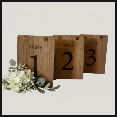 Three wooden table numbers (1, 2, and 3) with a small floral arrangement.