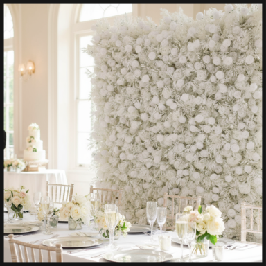 Elegant event space featuring a floral wall and beautifully set dining tables.