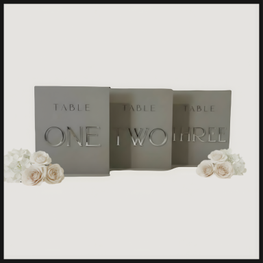 Three grey cards with cut-out numbers one, two, and three, surrounded by white flowers.