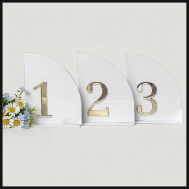 Three decorative table numbers, 1, 2, and 3, with a small bouquet of flowers.