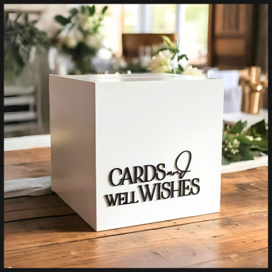 White card box with "Cards & Well Wishes" in elegant black lettering on a wooden table.